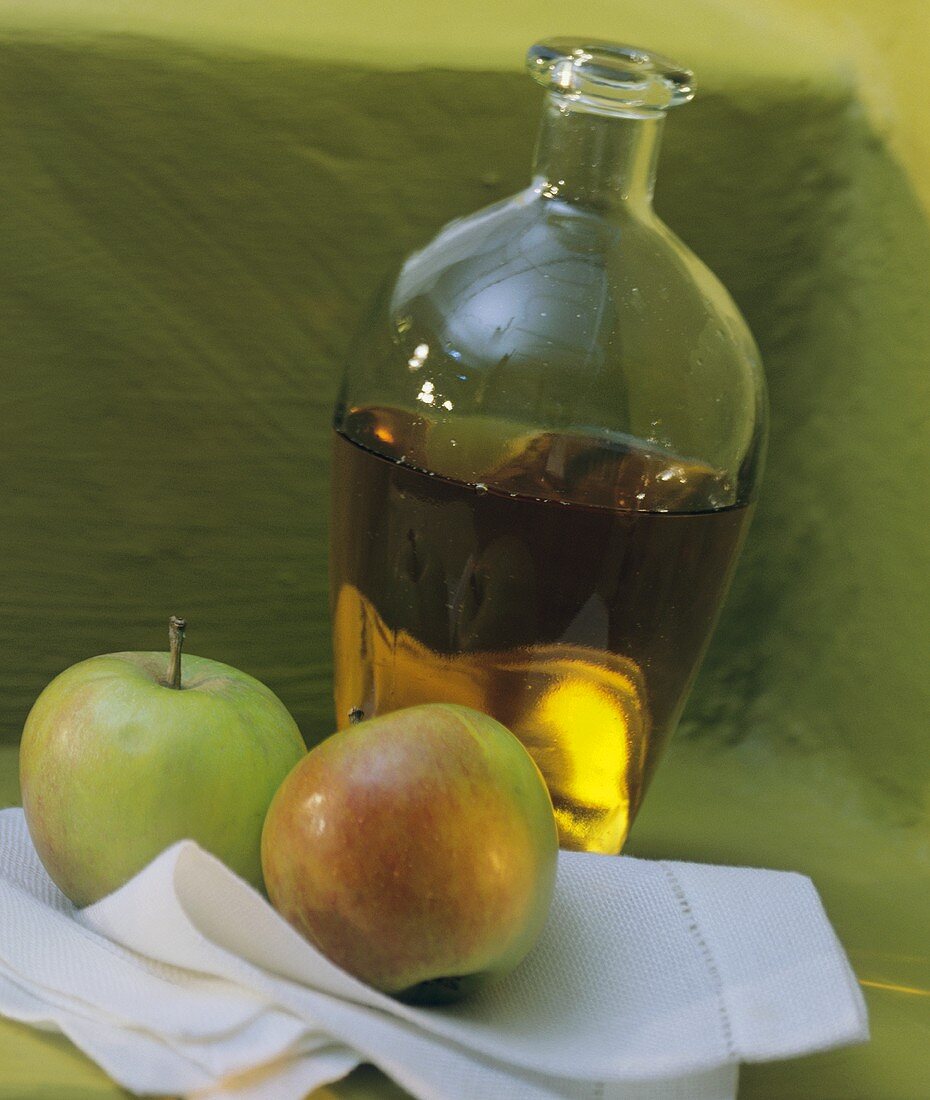 Karaffe mit Apfelessig, Deko: zwei frische Äpfel
