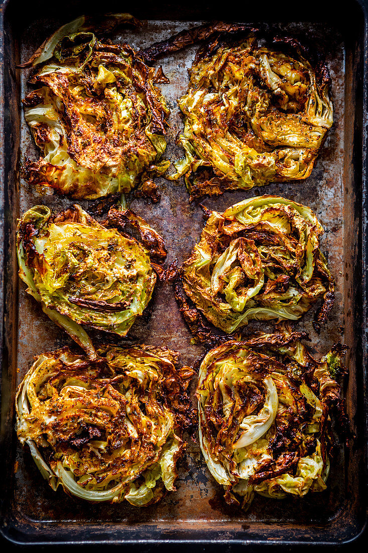 White cabbage steaks on a baking tray