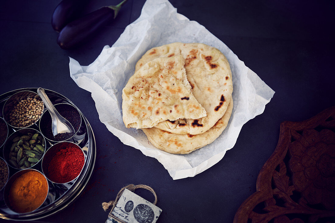 Naan bread on greaseproof paper and masala box