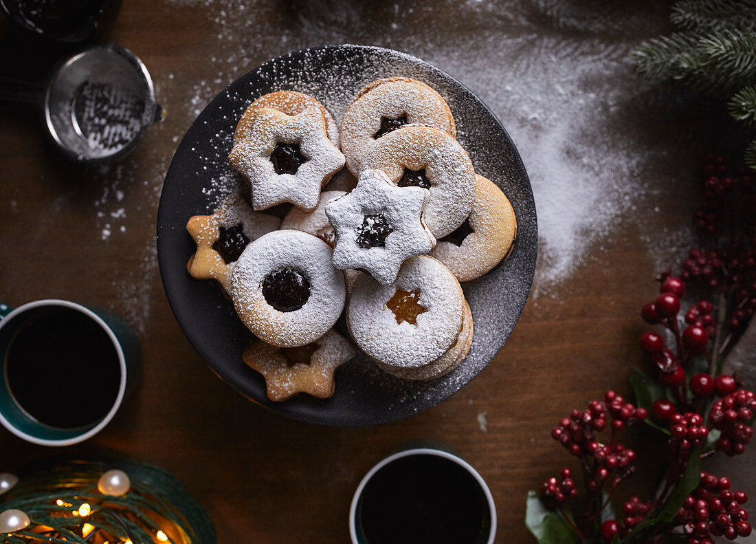 Freshly baked Linzer cookies being dusted with sugar