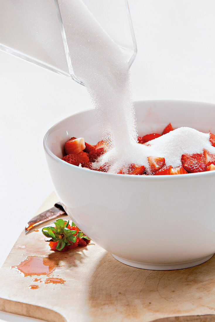 Making jam - adding preserving sugar to strawberry pieces