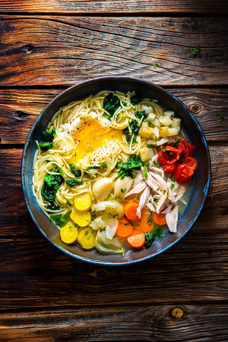 Chicken soup with pasta, vegetables and egg