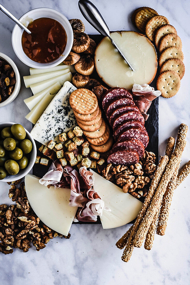 Cheese and salami board with crackers and olives