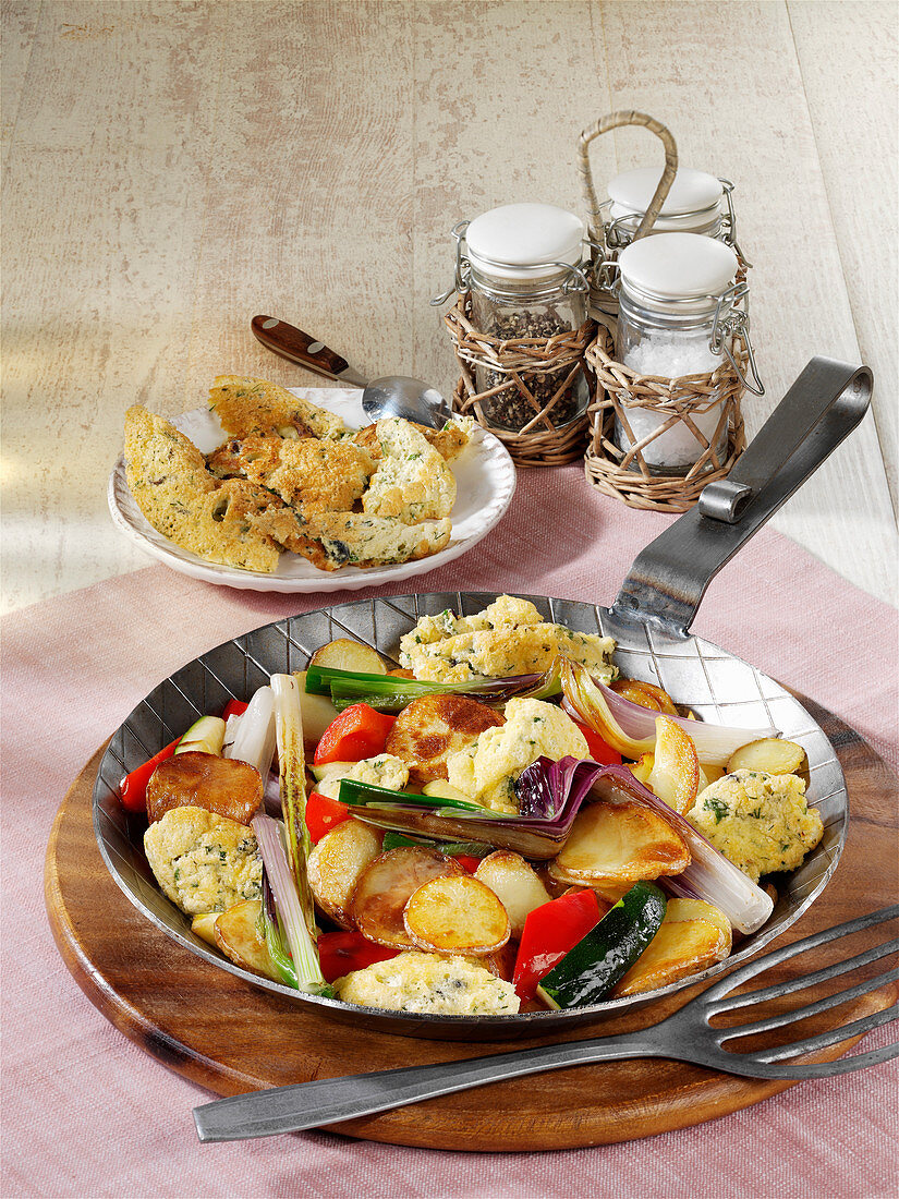 Fried potatoes with pancakes, Mediterranean vegetables and cheese