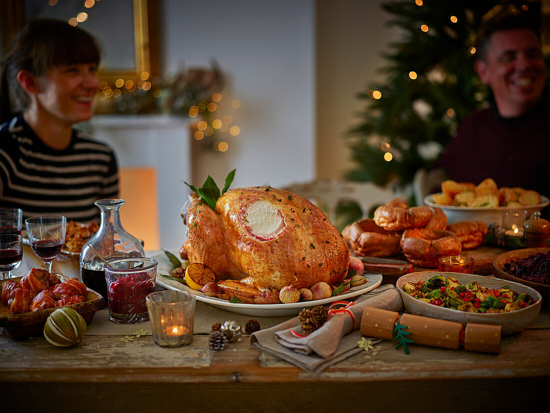 Familie beim traditionellen Weihnachtsessen mit Truthahn und Beilagen (England)