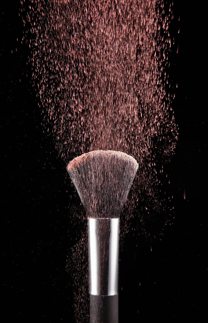 Blush powder blowing from makeup brush