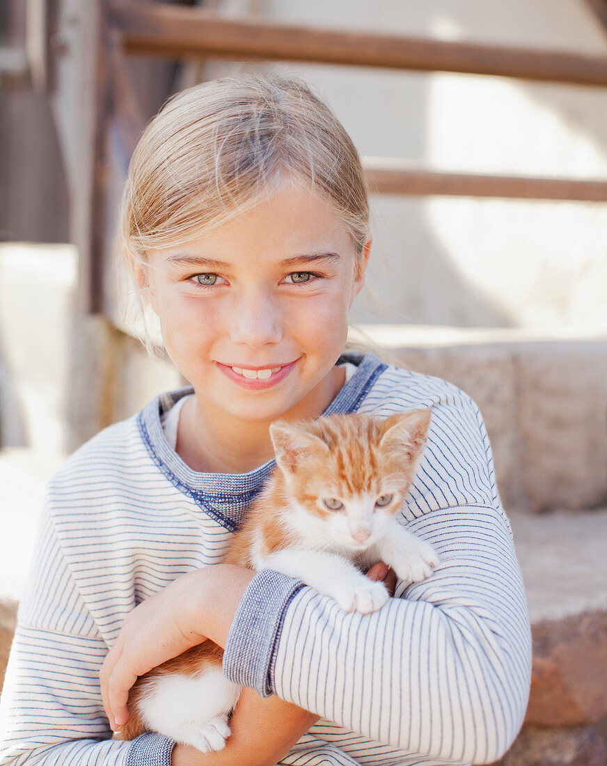 Portrait of smiling girl holding kitten