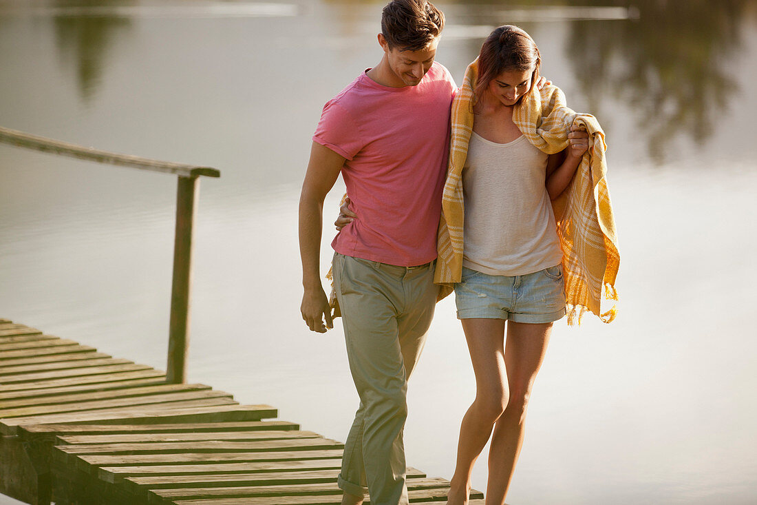 Couple walking on dock over lake