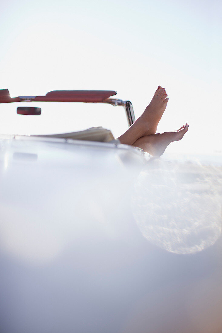 Woman's feet resting on convertible