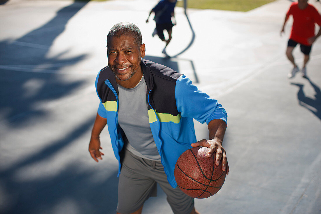 Older man playing basketball on court