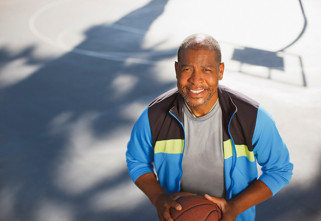 Older man playing basketball on court