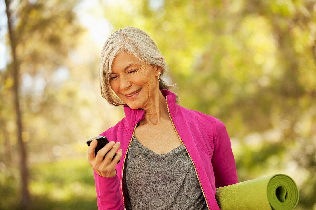 Older woman using cell phone outdoors