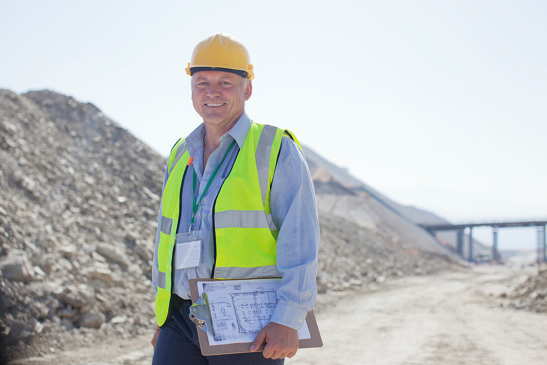 Businessman carrying clipboard in quarry