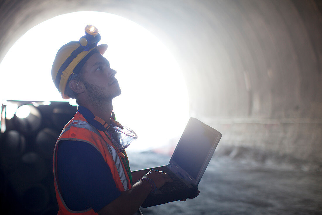 Worker using laptop in tunnel