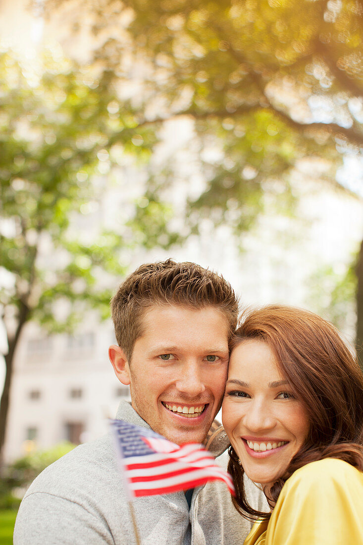 Couple waving American flag in urban park