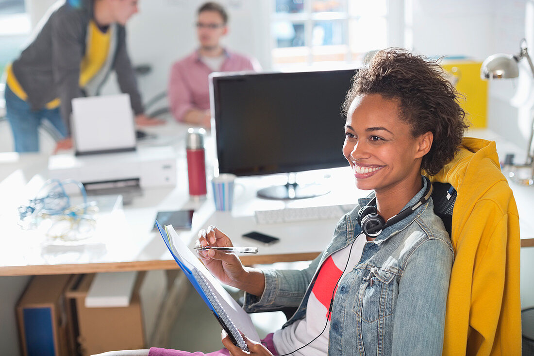 Businesswoman making notes at desk