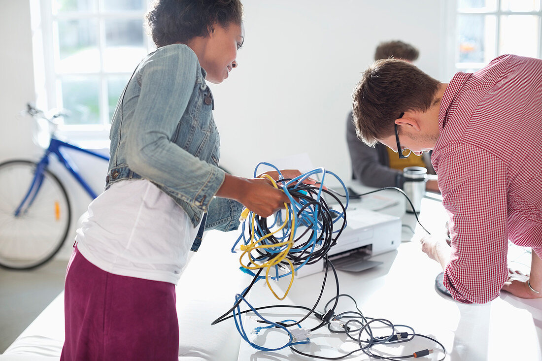 Business people untangling cords