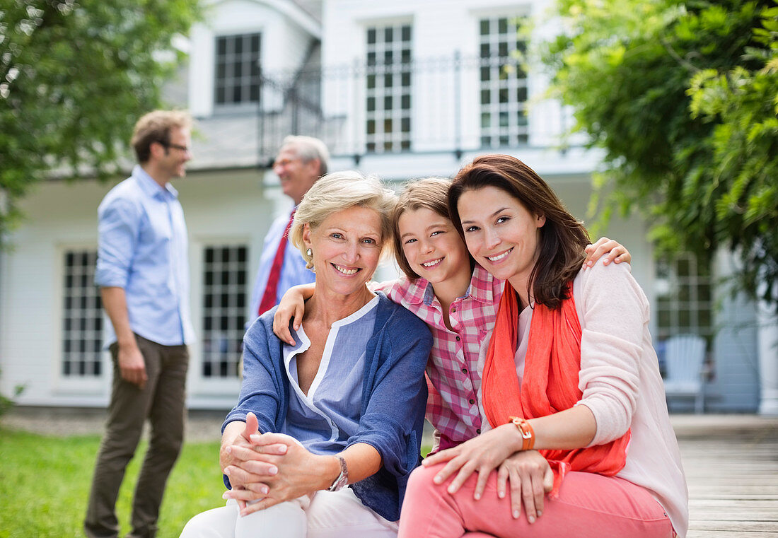 Family smiling together outside house