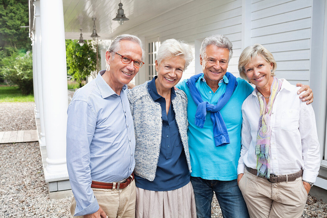 Friends standing together outside house