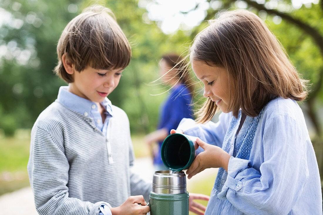 Children pouring tea from thermos