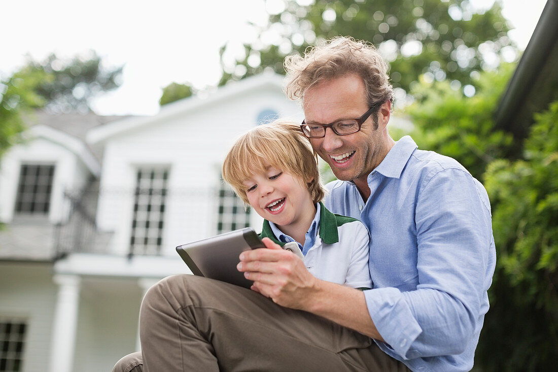 Father and son using digital tablet