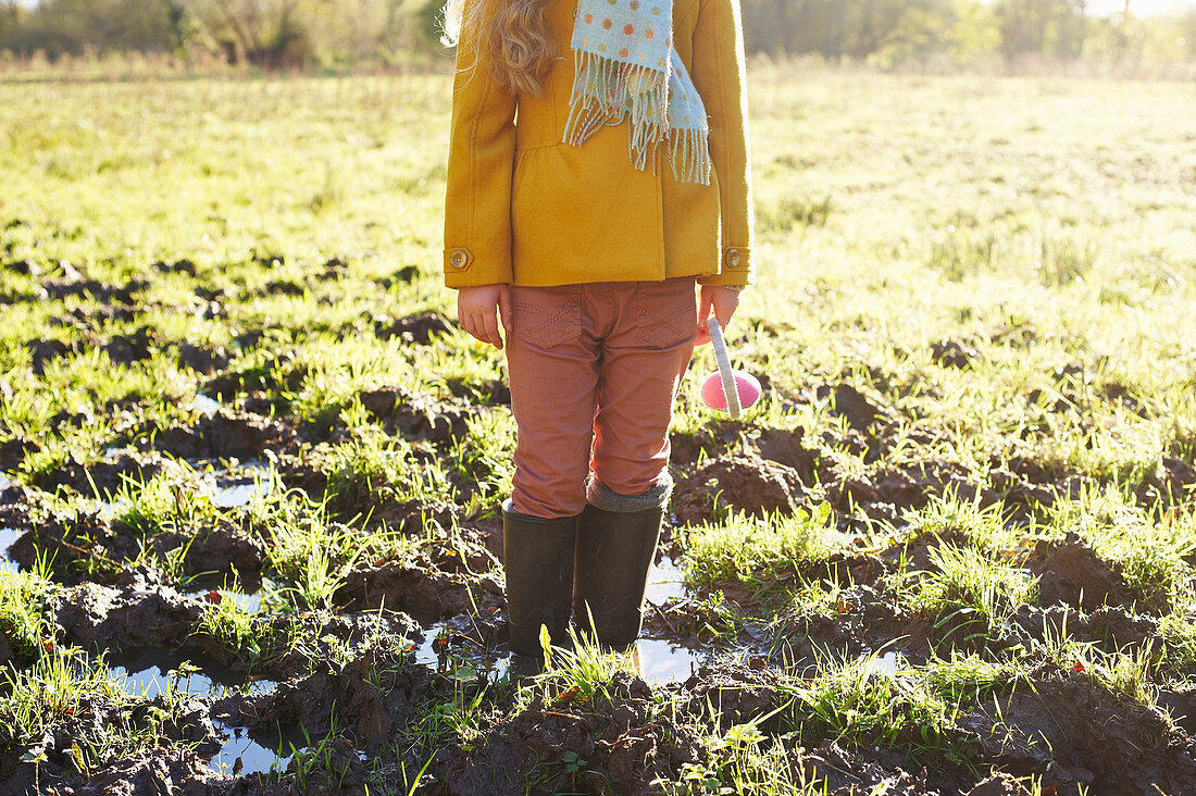 Girl standing in muddy field