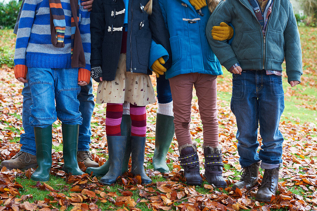 Children standing in autumn leaves