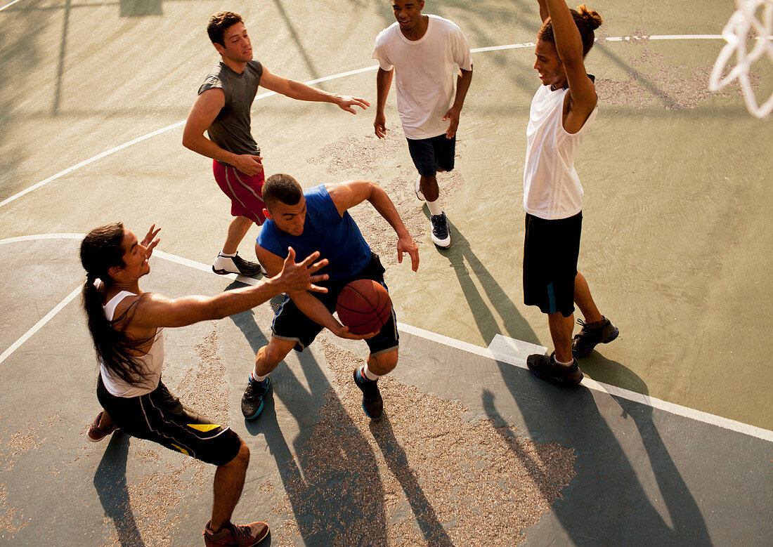 Men playing basketball on court