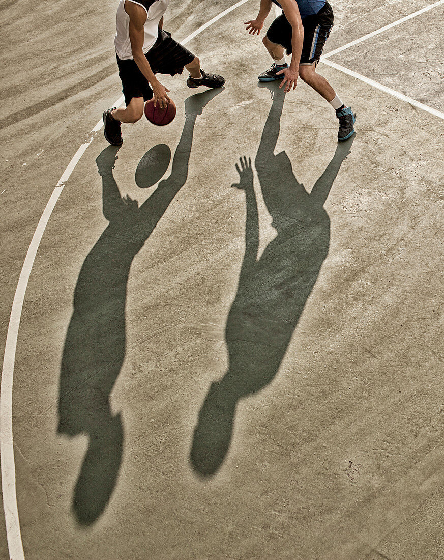 Men playing basketball on court