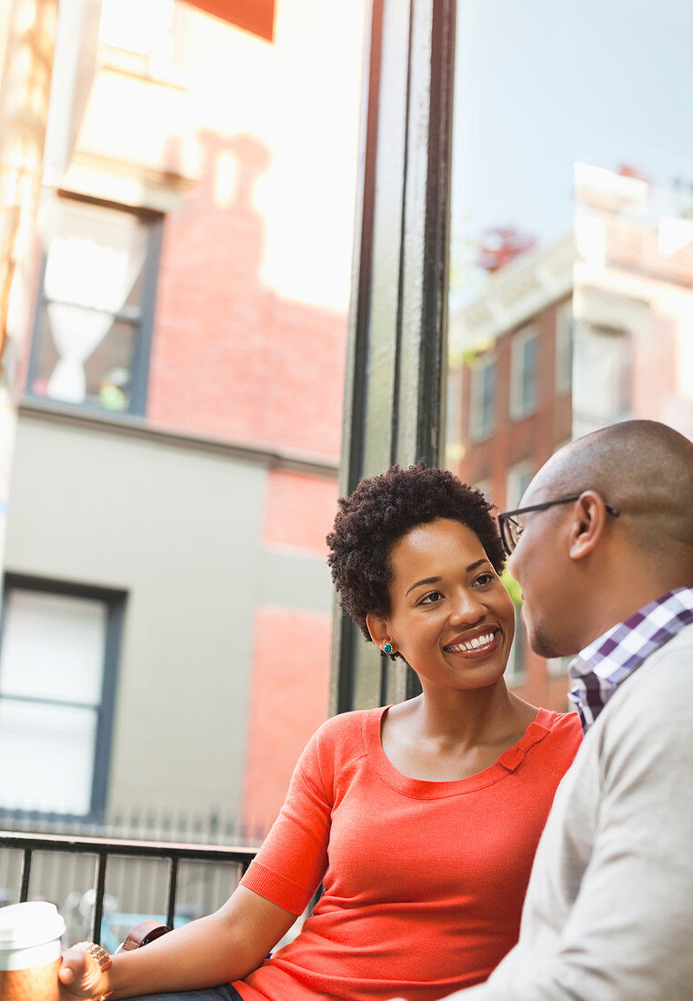 Couple having coffee on city street