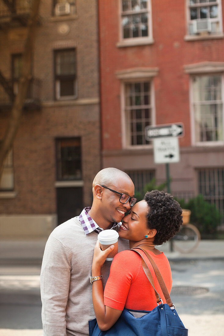 Couple hugging on city street