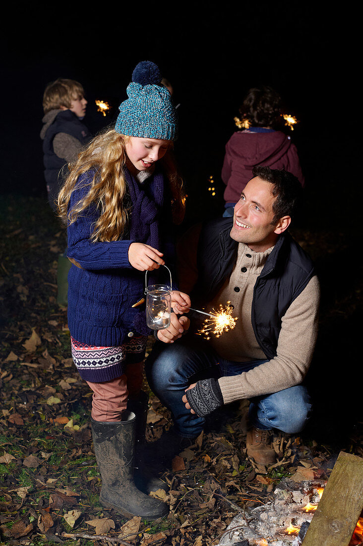 Father and daughter playing with sparkler