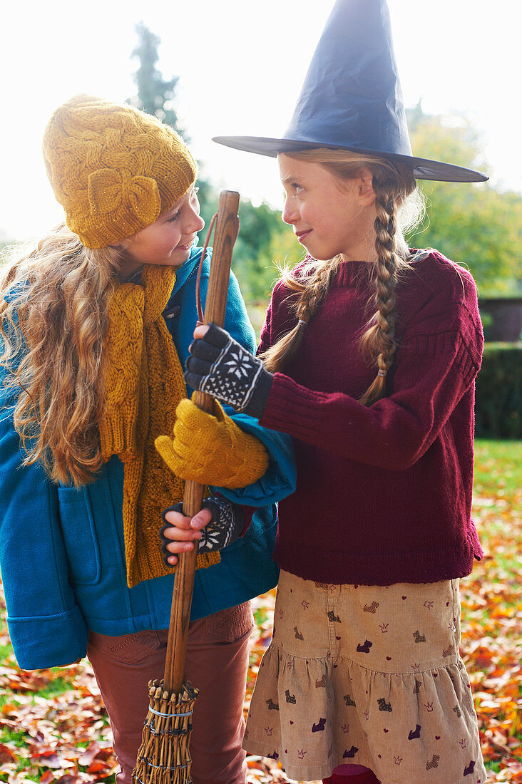 Girls playing with witch's hat and broom