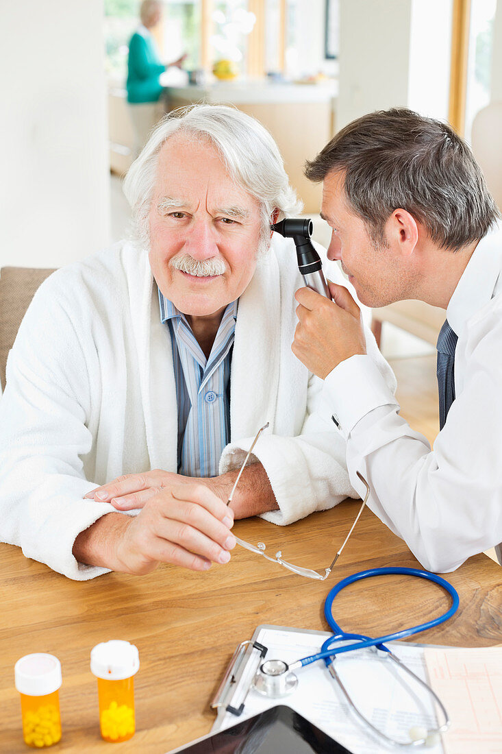 Doctor examining man's ear