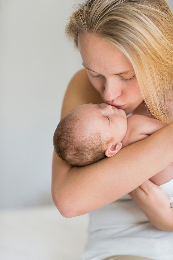 Mother kissing newborn baby