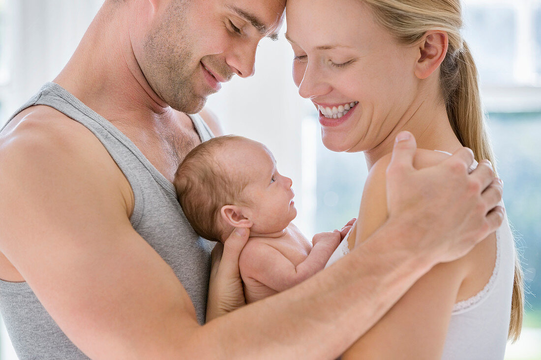 Parents cradling newborn baby