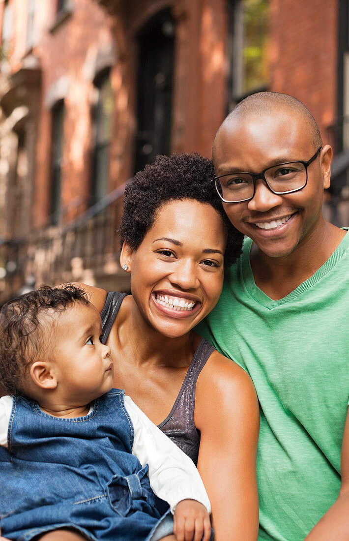 Family smiling together on city street