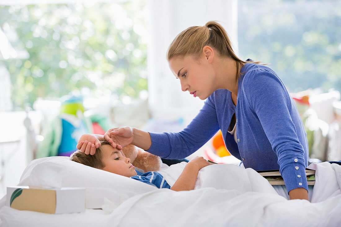 Mother feeling son's forehead