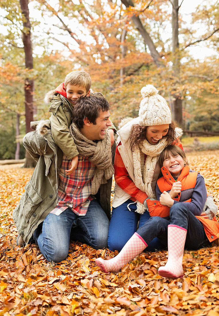 Family playing together in autumn leaves