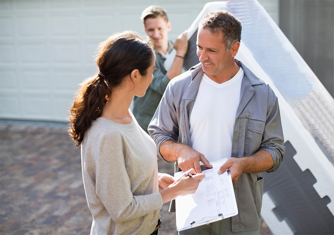 Woman signing for package in driveway