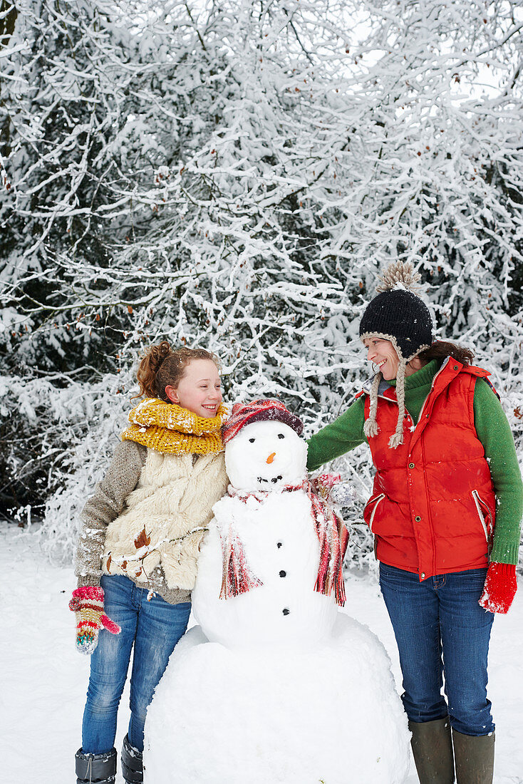 Mother and daughter with snowman