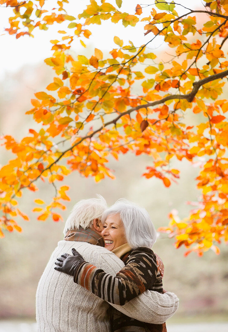 Older couple hugging in park