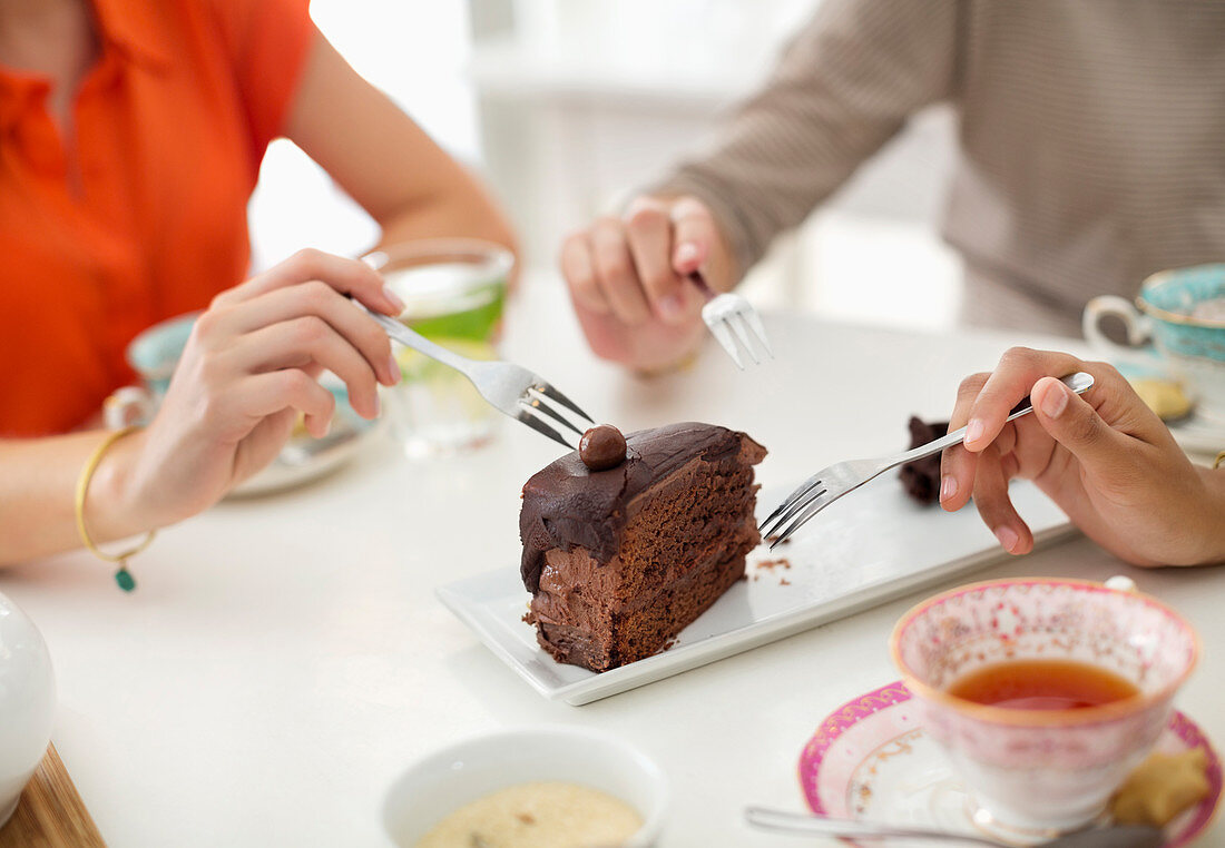 Women sharing slice of cake