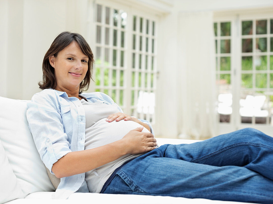 Pregnant woman relaxing on sofa