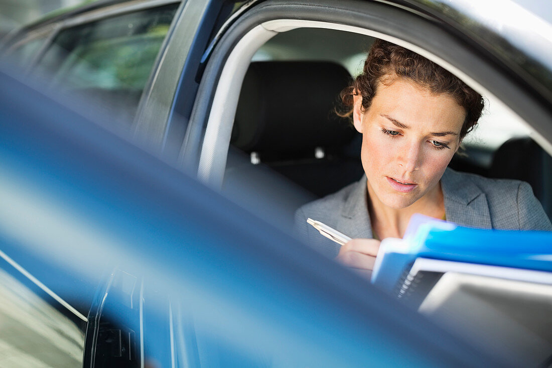 Businesswoman working in car