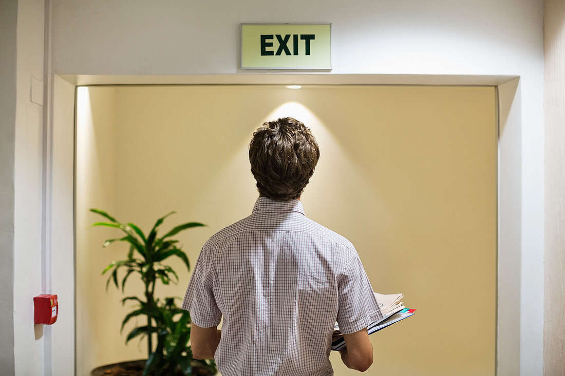 Businessman examining exit' sign