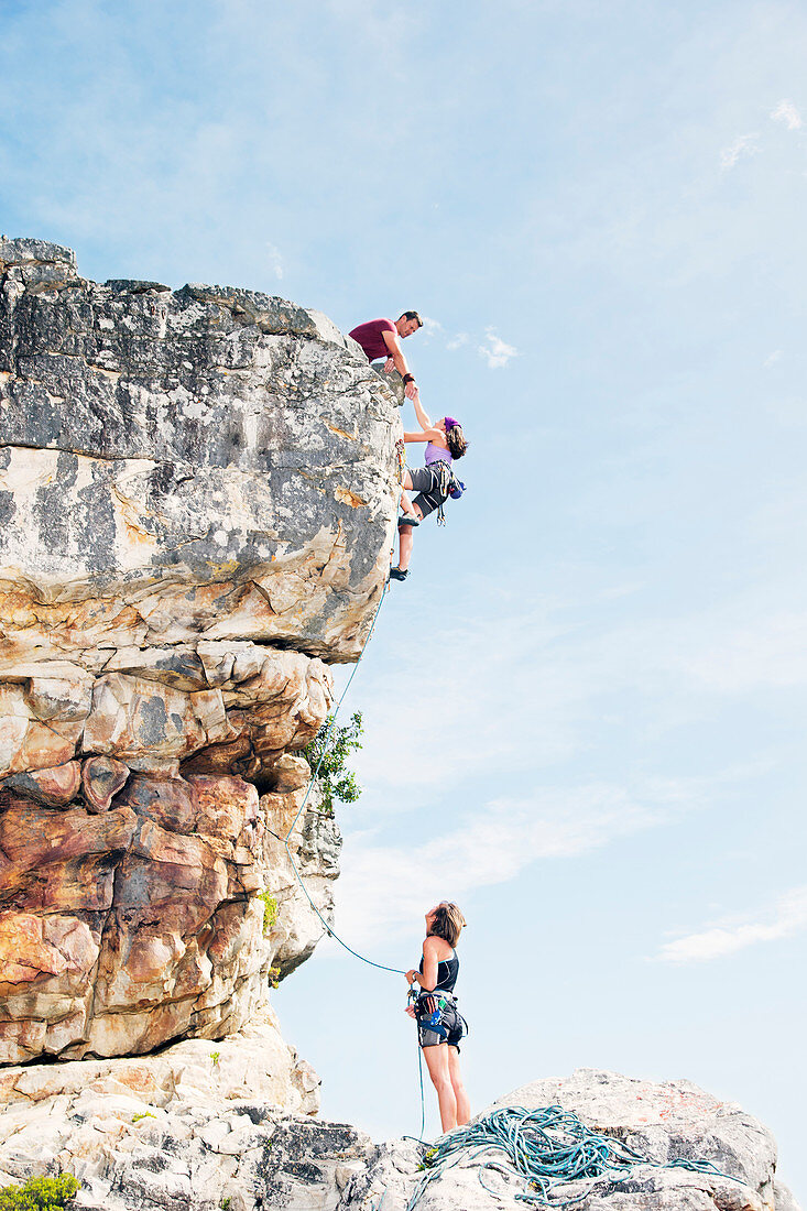 Climbers scaling steep rock face
