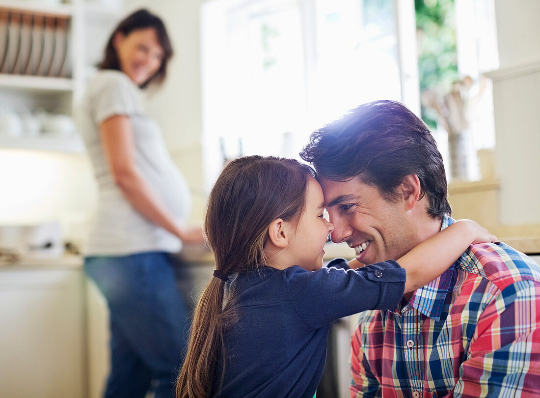 Father and daughter hugging in kitchen