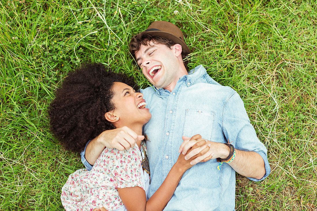 Laughing couple laying in grass