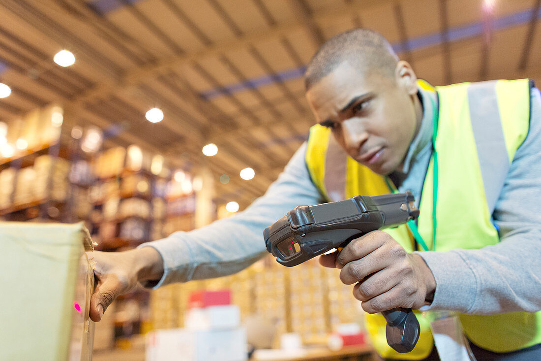 Worker scanning boxes in warehouse